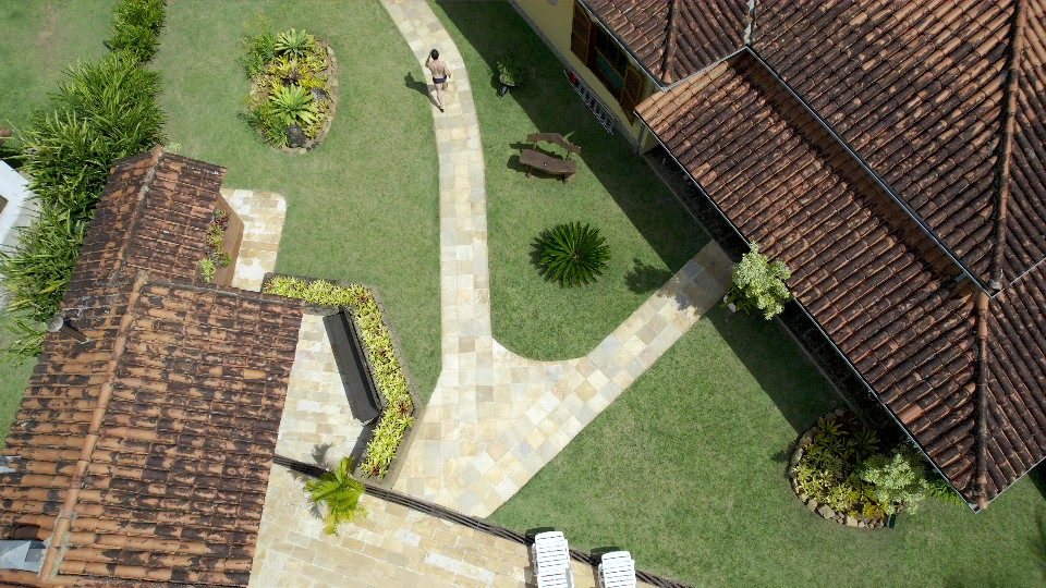 Caminho de pedra entre canteiros ligando as áreas da casa